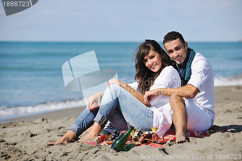 Image of young couple enjoying  picnic on the beach