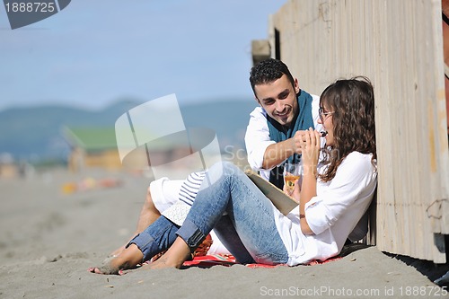 Image of young couple enjoying  picnic on the beach