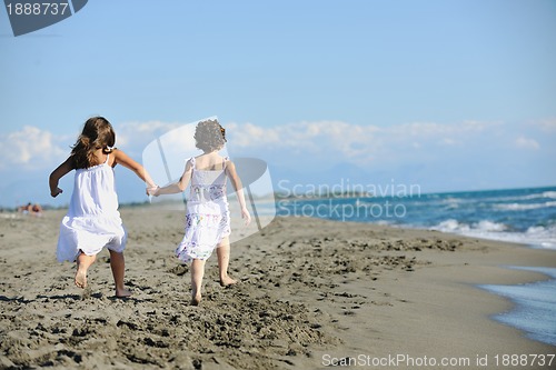 Image of cute little girls running on beach