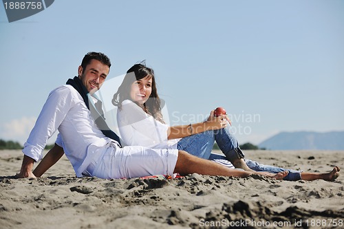 Image of young couple enjoying  picnic on the beach