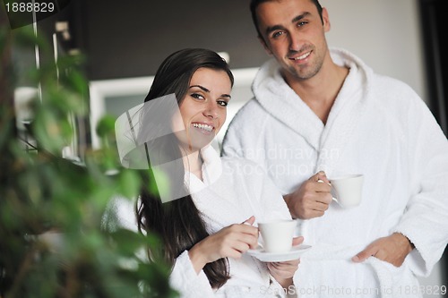 Image of Young love couple taking fresh morning cup of coffee