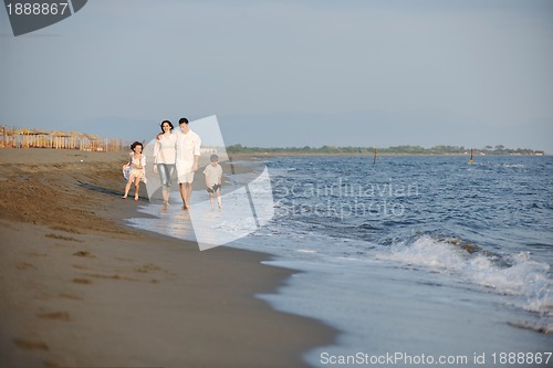 Image of happy young family have fun on beach at sunset
