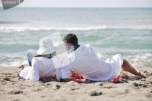 Image of young couple enjoying  picnic on the beach