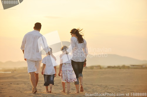 Image of happy young family have fun on beach at sunset