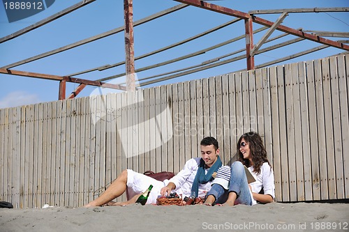Image of young couple enjoying  picnic on the beach