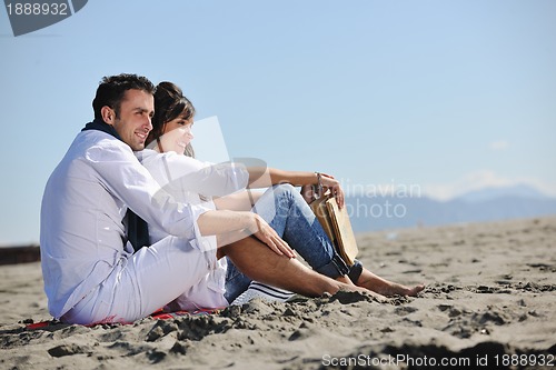 Image of young couple enjoying  picnic on the beach