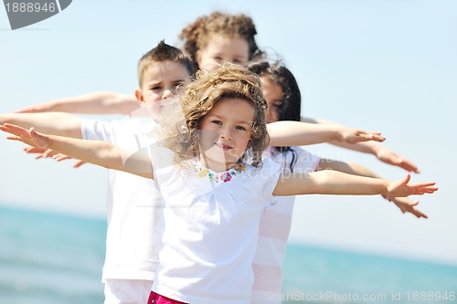 Image of happy child group playing  on beach