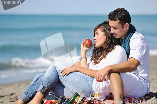 Image of young couple enjoying  picnic on the beach