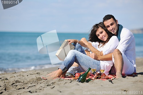 Image of young couple enjoying  picnic on the beach