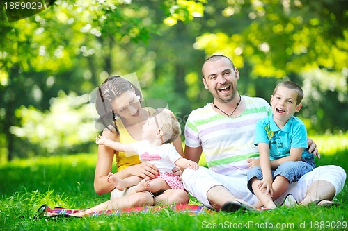 Image of happy young couple with their children have fun at park
