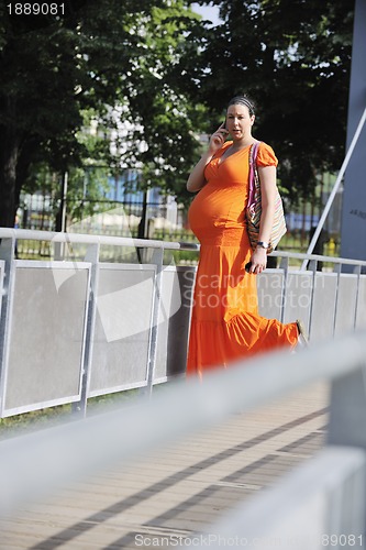 Image of happy pregnant woman talking by cellphone