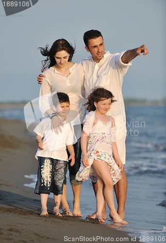 Image of happy young family have fun on beach at sunset