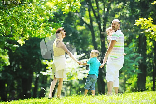 Image of happy young couple with their children have fun at park