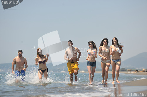Image of happy people group have fun and running on beach