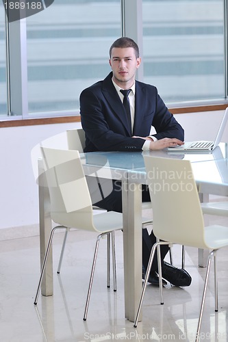 Image of young business man alone in conference room