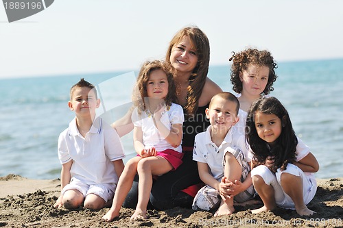 Image of group portrait of childrens with teacher on beach