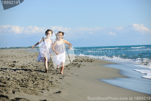 Image of cute little girls running on beach