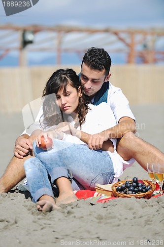 Image of young couple enjoying  picnic on the beach