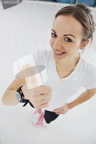 Image of happy diet concept with young woman on pink scale