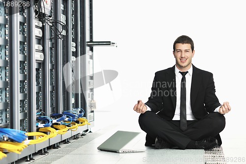 Image of business man practice yoga at network server room