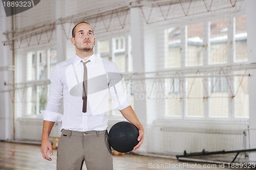 Image of businessman holding basketball ball