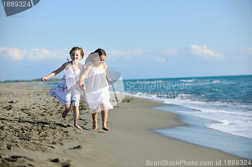 Image of cute little girls running on beach