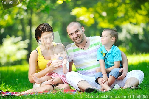 Image of happy young couple with their children have fun at park