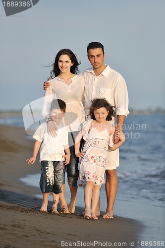 Image of happy young family have fun on beach at sunset