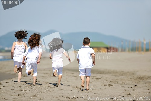 Image of happy child group playing  on beach