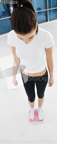 Image of happy diet concept with young woman on pink scale