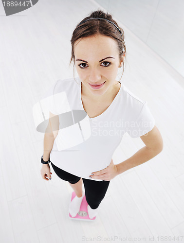 Image of happy diet concept with young woman on pink scale