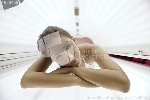 Image of Beautiful young woman tanning in solarium