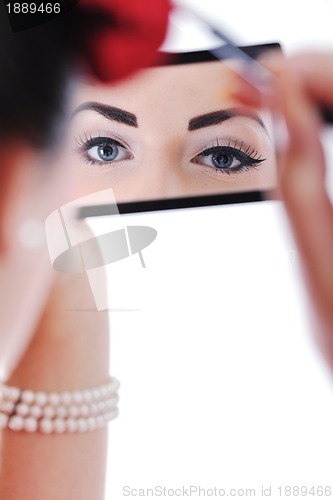 Image of beautiful young woman applying makeup