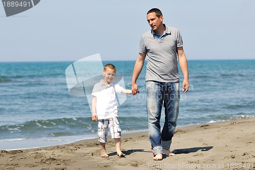 Image of happy father and son have fun and enjoy time on beach
