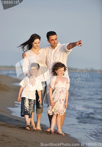 Image of happy young family have fun on beach at sunset