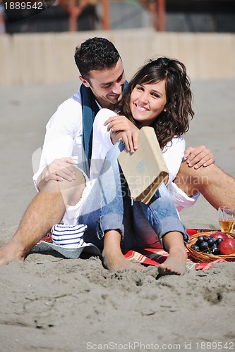 Image of young couple enjoying  picnic on the beach