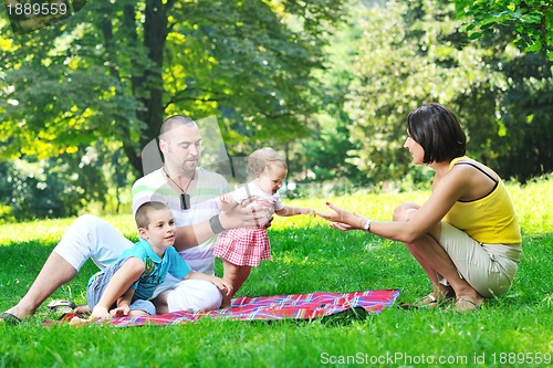 Image of happy young couple with their children have fun at park