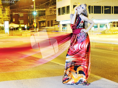 Image of elegant woman on city street at night