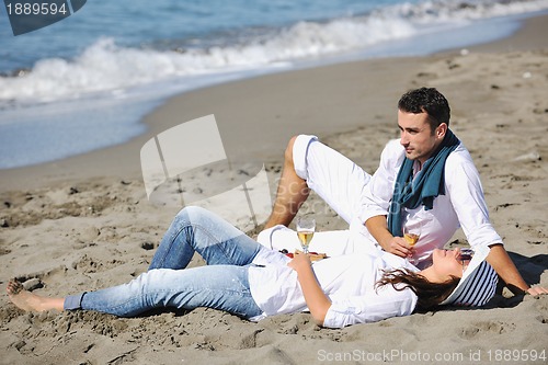 Image of young couple enjoying  picnic on the beach