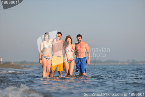 Image of happy people group have fun and running on beach