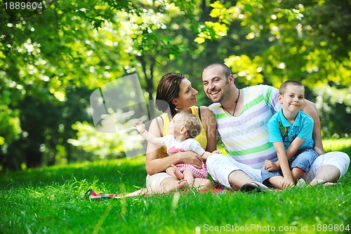 Image of happy young couple with their children have fun at park