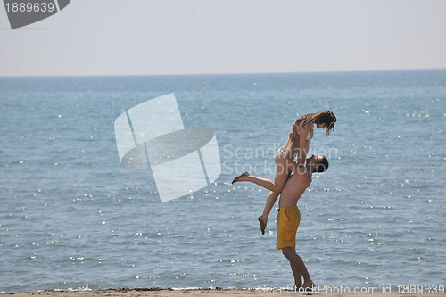 Image of happy young couple have fun on beach