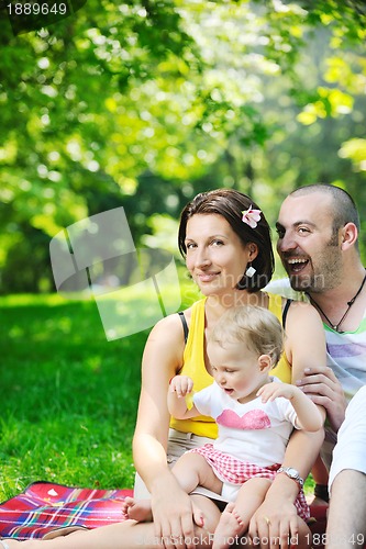 Image of happy young couple with their children have fun at park
