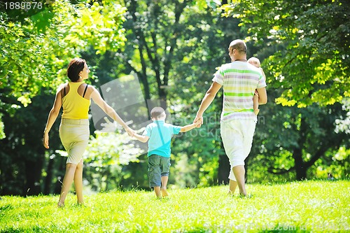 Image of happy young couple with their children have fun at park