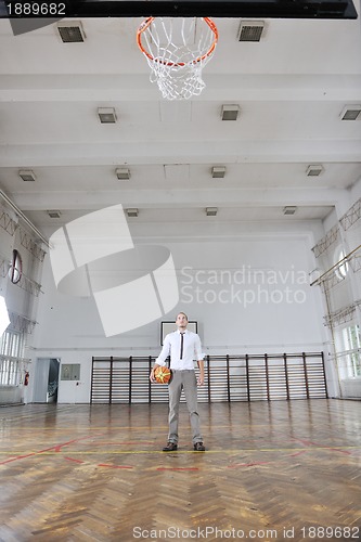 Image of businessman holding basketball ball