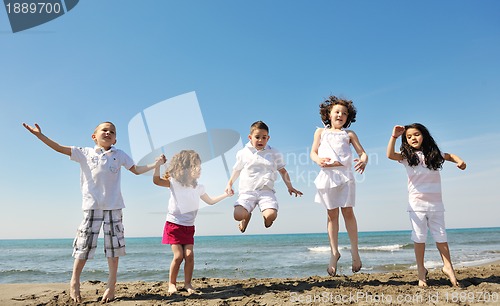 Image of happy child group playing  on beach