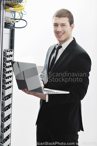 Image of businessman with laptop in network server room