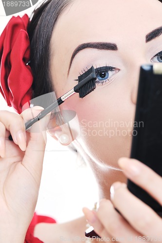 Image of beautiful young woman applying makeup