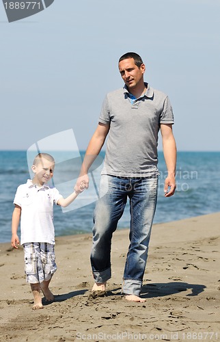 Image of happy father and son have fun and enjoy time on beach