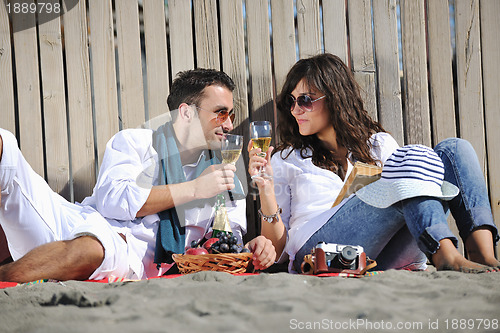 Image of young couple enjoying  picnic on the beach